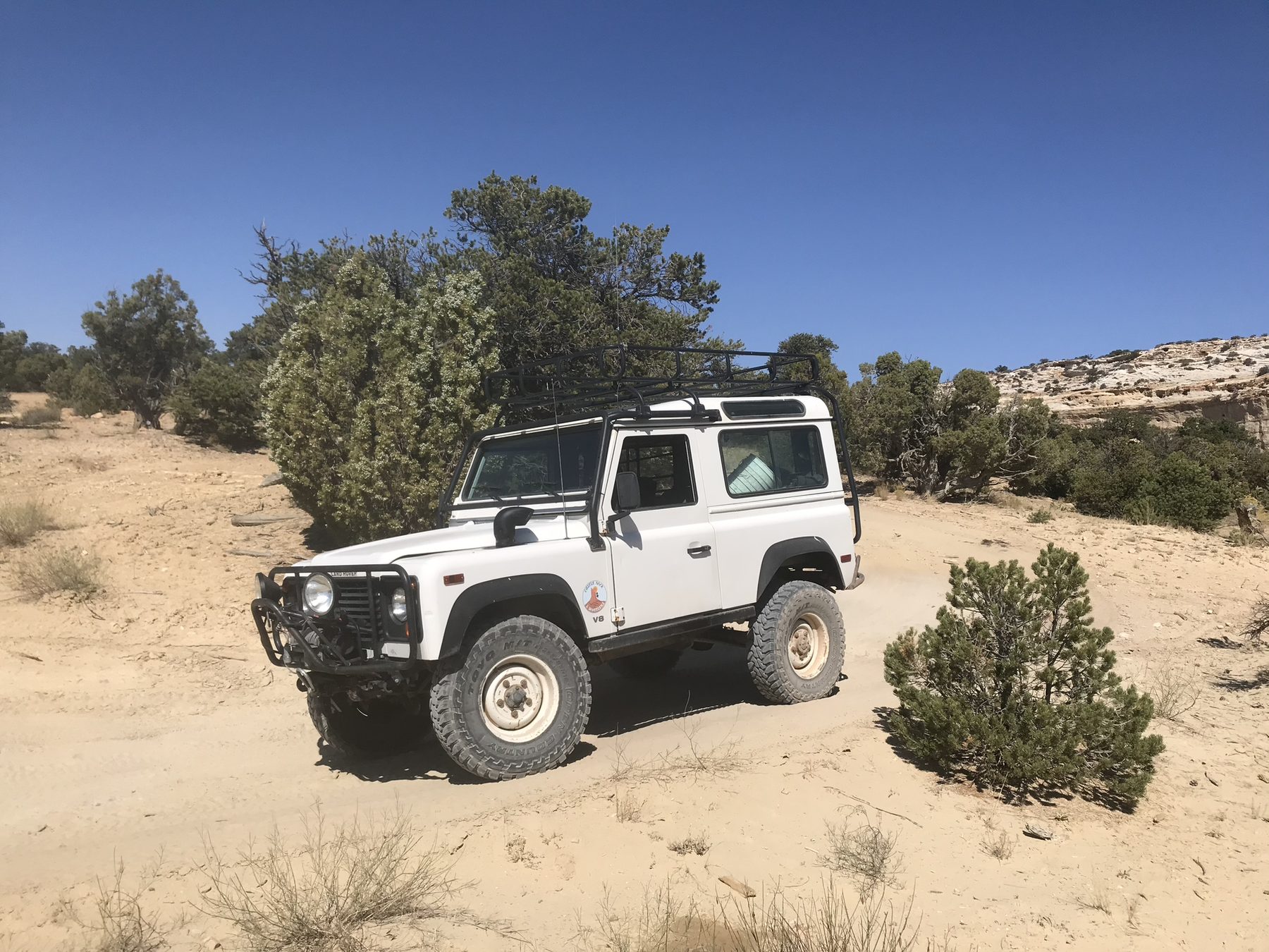 White Defender on a sandy desert road
