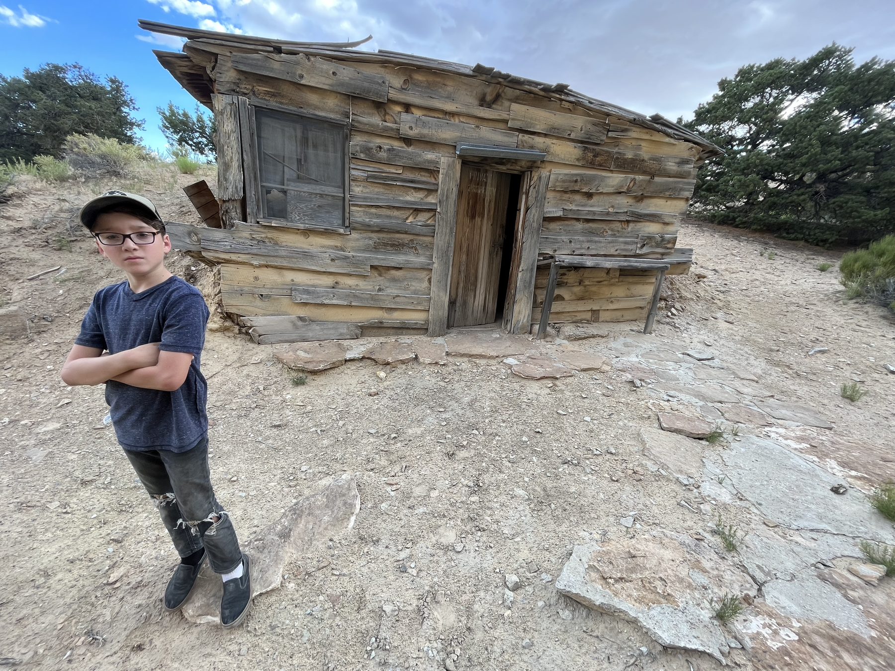 A guide standing near an old desert cabin