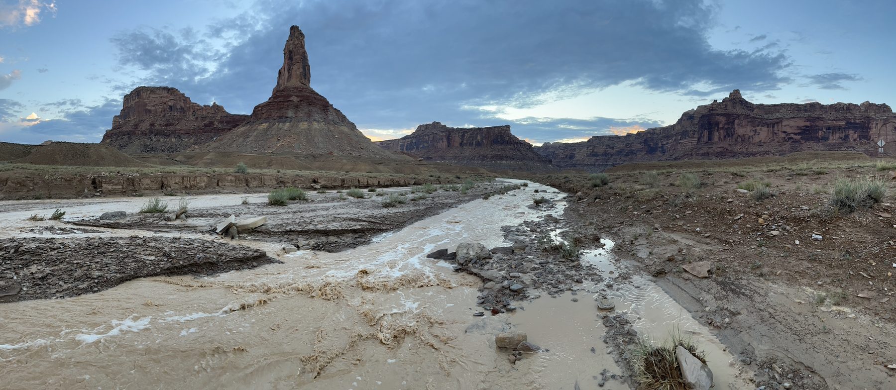 A wide muddy river winding through desert canyon country